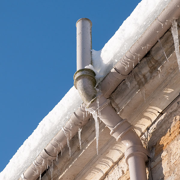 Icicles hanging from the gutter, and snow on the roof causing drainage problems